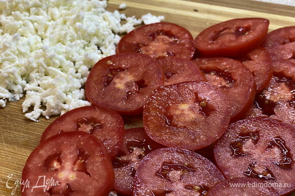 Натрите на терке моцареллу и нарежьте помидоры кружочками. Если помидоры неспелые, присыпьте их щепоткой сахара.