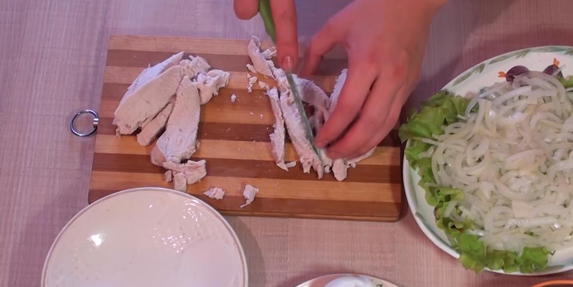 Измельчение куриного филе ножом на доске для салата